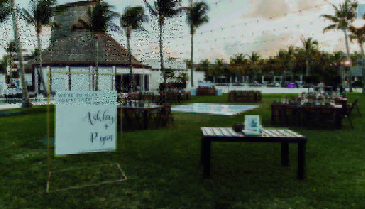 7 be all inclusive Outdoor wedding reception on a grassy lawn with string lights, palm trees, andため arranged dining tables; a welcome sign for Ashley and Ryan stands at the front.