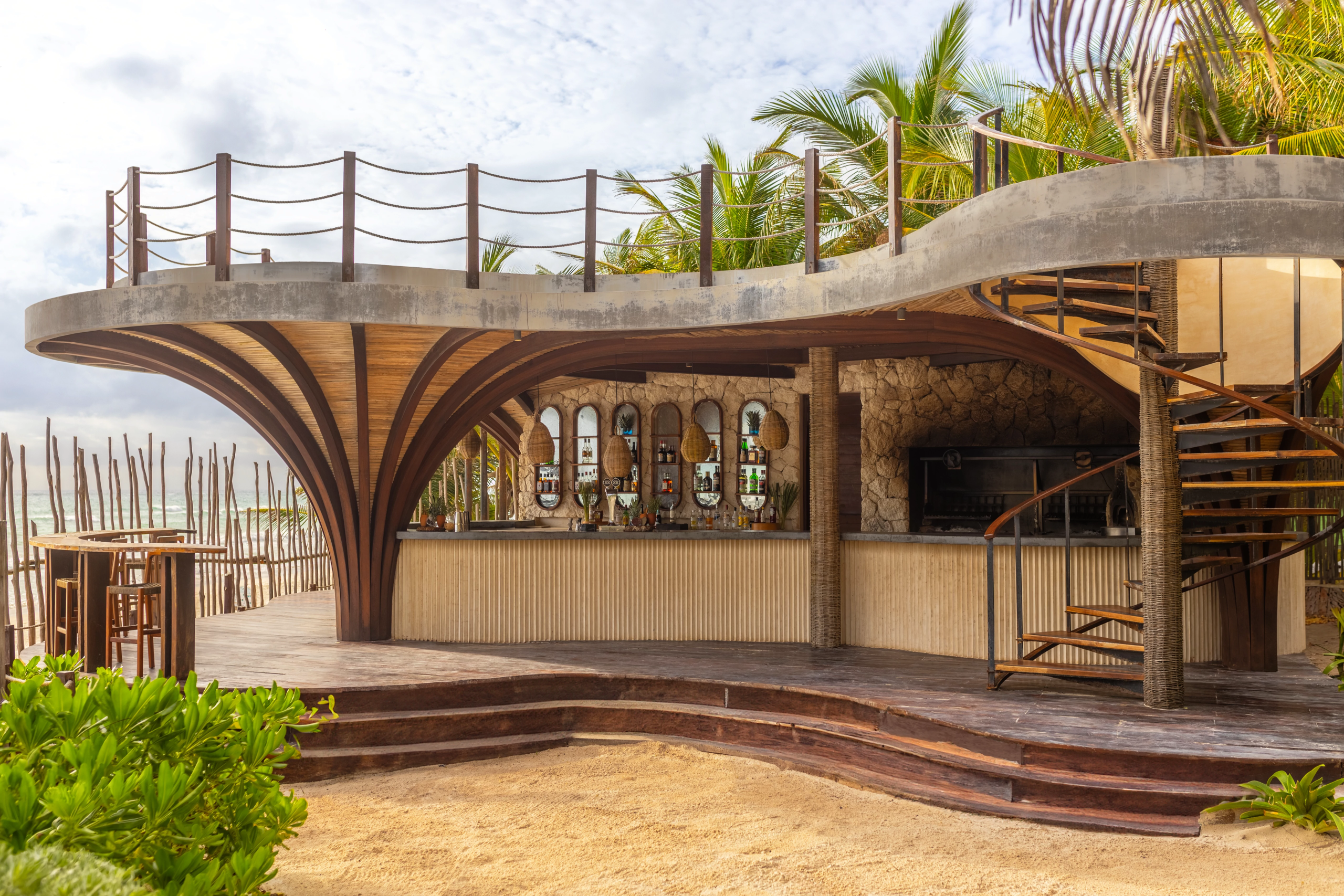 sectubarbeachclubwillysplace01afc be all inclusive Open-air beach bar with a curved wooden canopy, palm trees, and a railing along the upper deck