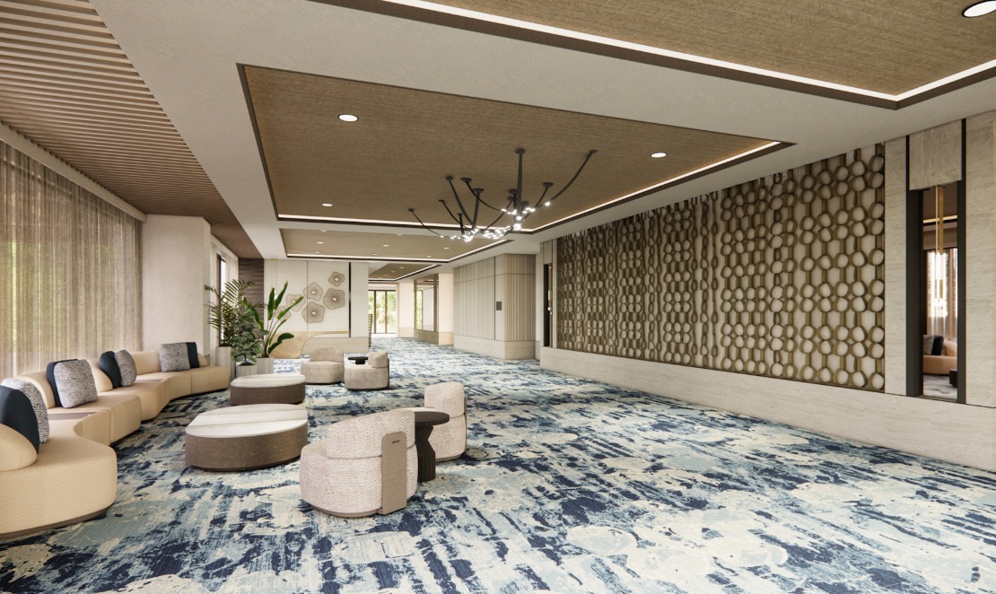screenshot 20260710 131332 be all inclusive Spacious hotel lobby with beige curved seating, round ottomans, and a blue abstract carpet.